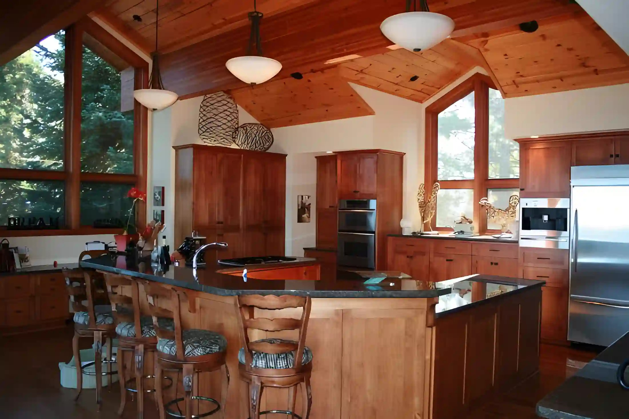 Custom timber kitchen with high windows and stone counters
